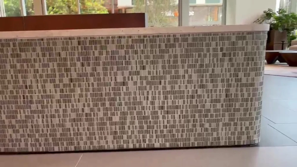 Precision mosaic tile finishing on a commercial reception desk by Evolution Tile Inc