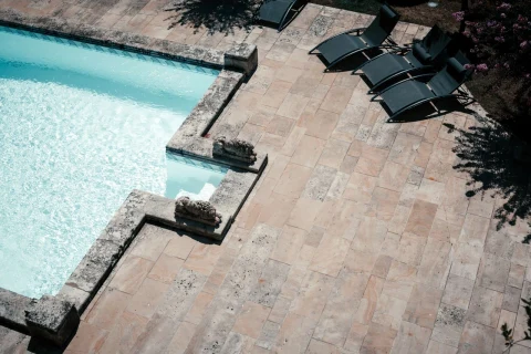 Pool deck with terracotta-look tile and sun loungers