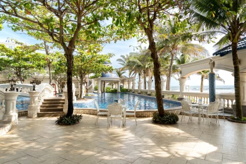 Pool patio with stone paving and palm trees