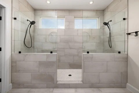 Walk-in shower tiled from floor to ceiling with two shower heads