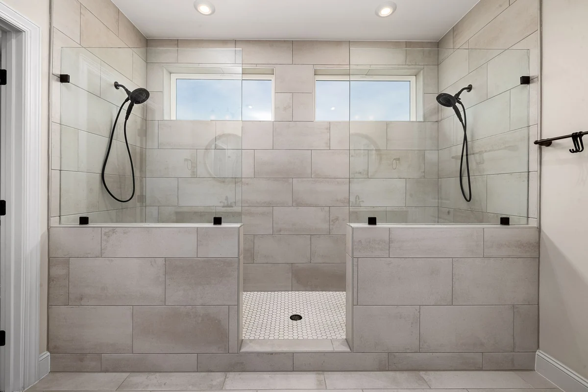 Walk-in shower tiled from floor to ceiling with two shower heads