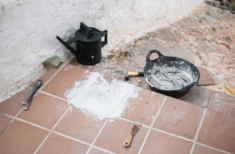 Tiling tools and mortar on a terracotta tile floor