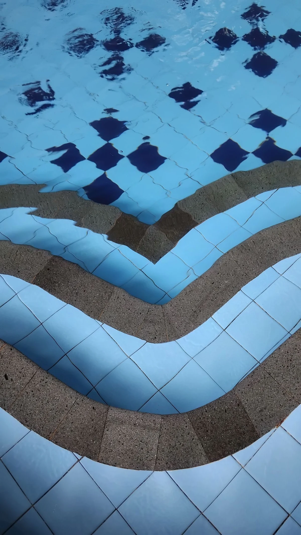 Pool steps finished in blue mosaic tile