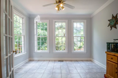 Bright empty room with large windows and a tile floor