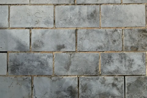 Gray wall tile with grout lines between each piece