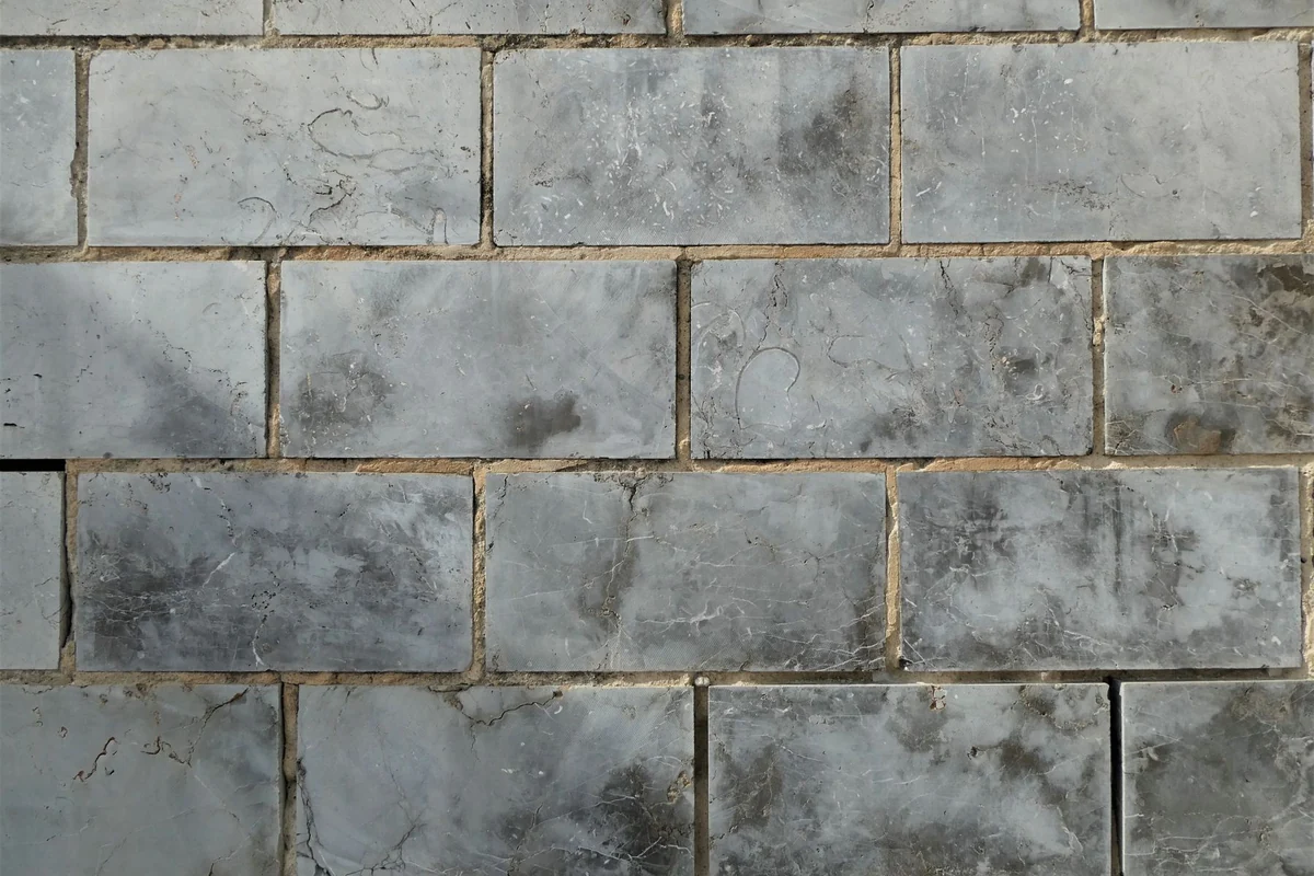 Gray wall tile with grout lines between each piece