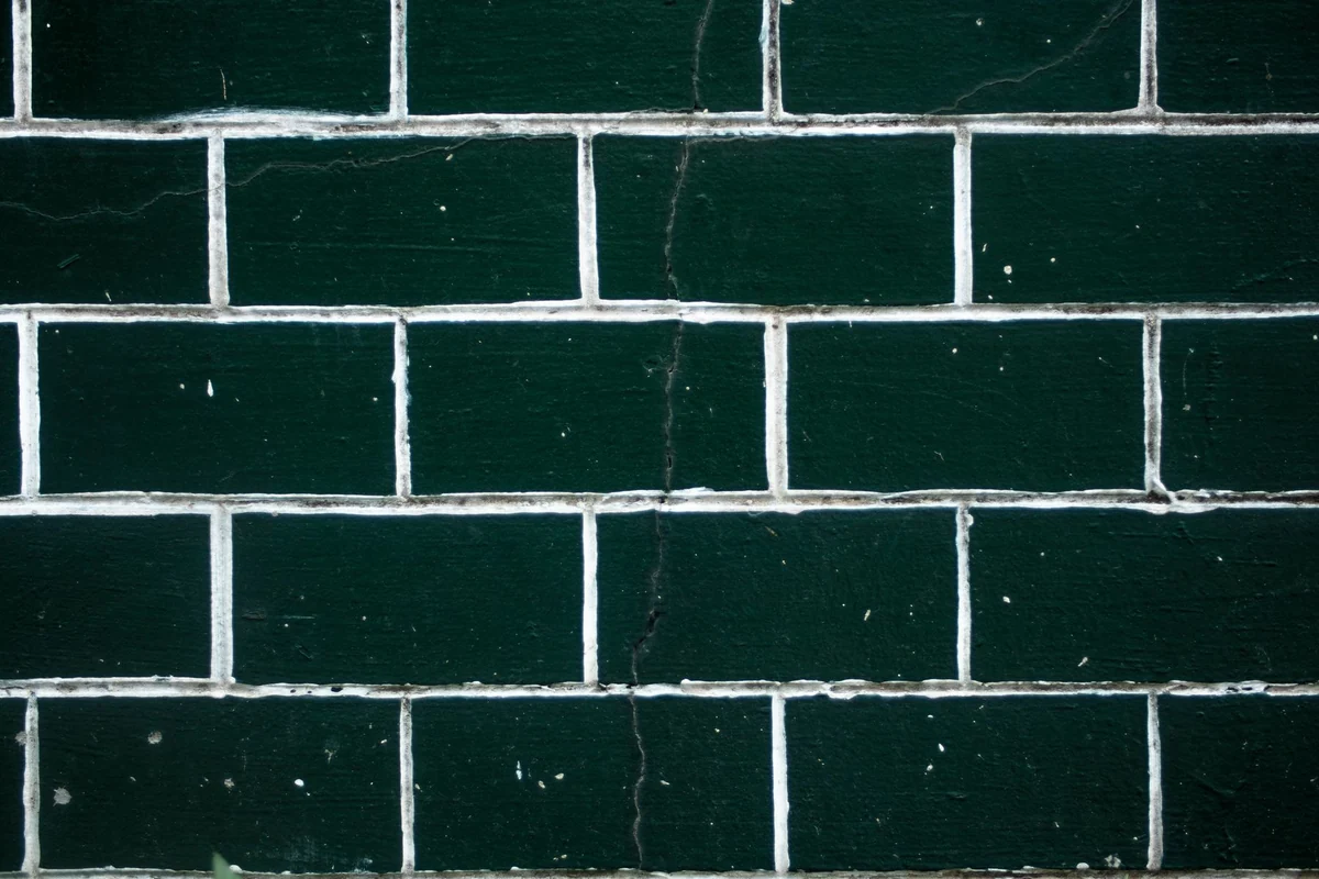 Dark green subway tile wall with white grout lines
