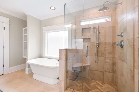 Bathroom with a tiled glass shower and a freestanding tub