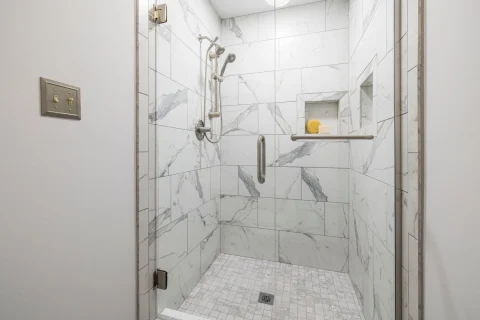 Shower with walls tiled in white marble-look porcelain