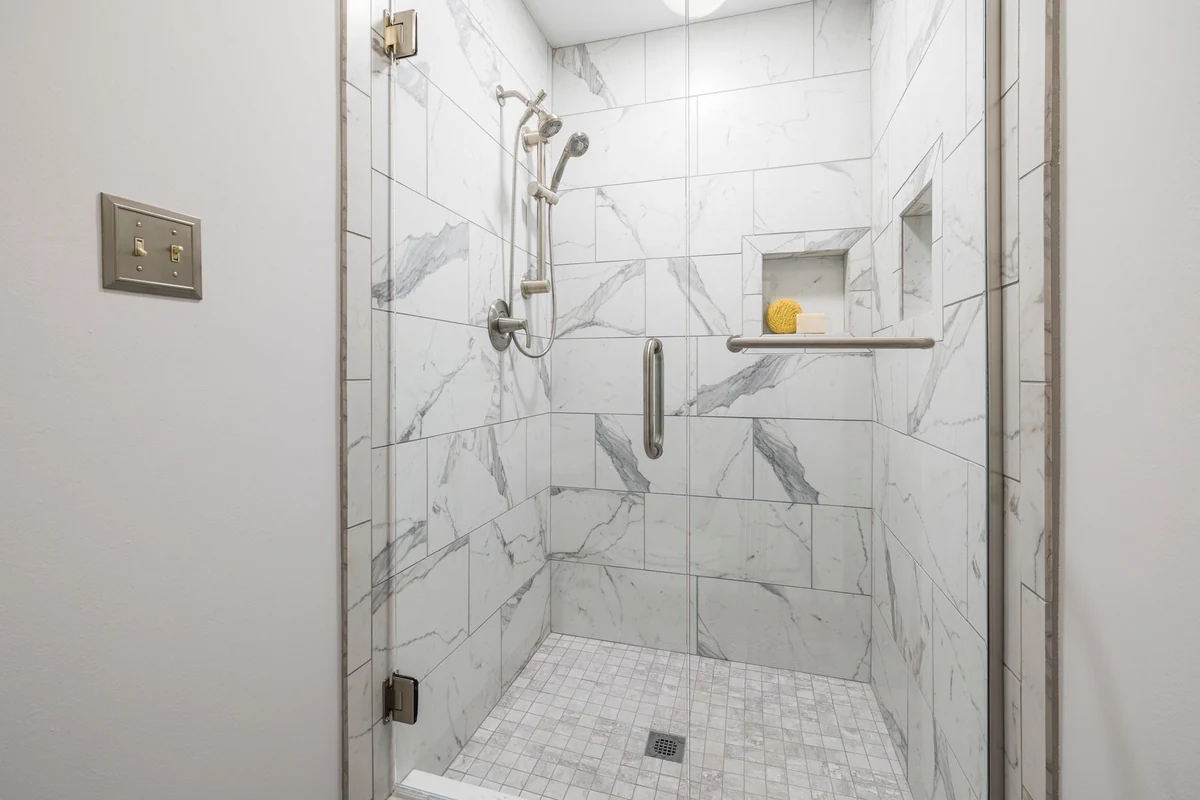 Shower with walls tiled in white marble-look porcelain